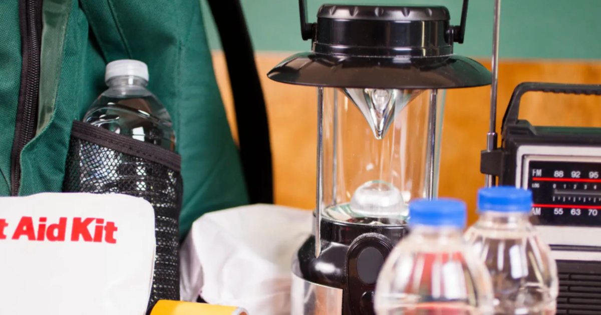 Items from an emergency preparedness kit, including water bottles, a lantern, a radio, and a first aid kit